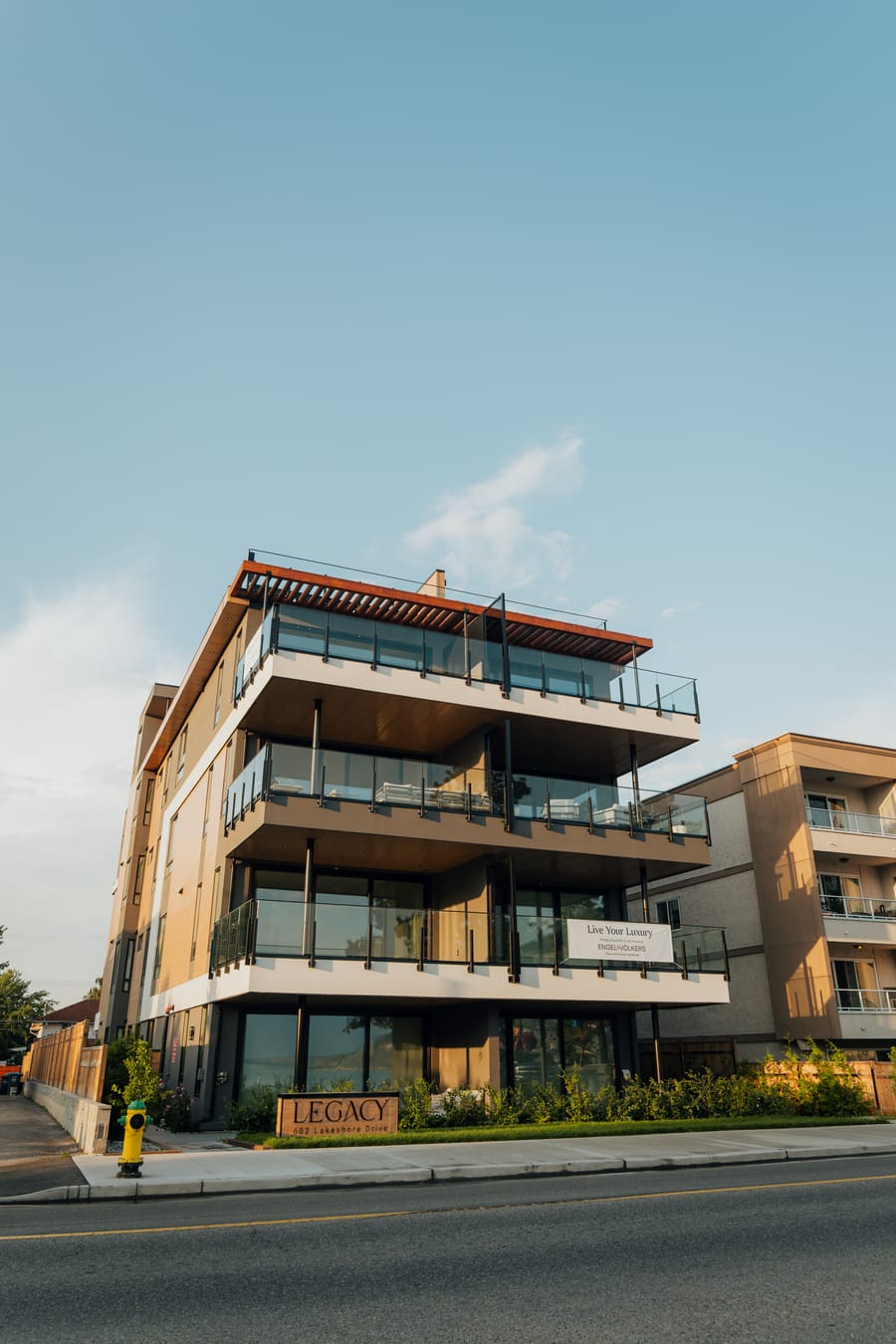 Street elevation of Legacy on Lakeshore with its stacked balconies and rooftop terrace